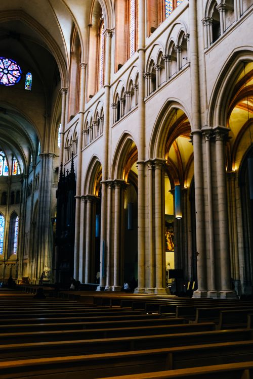Free Capture the serenity and grandeur of cathedral interiors, showcasing exquisite arches and wooden benches. Stock Photo