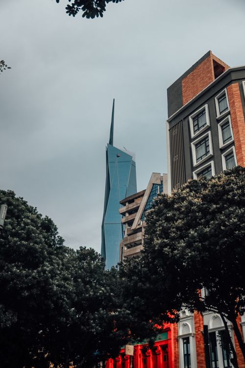 Free Tall glass skyscraper amidst older architectural styles under cloudy skies, creating a modern city contrast. Stock Photo