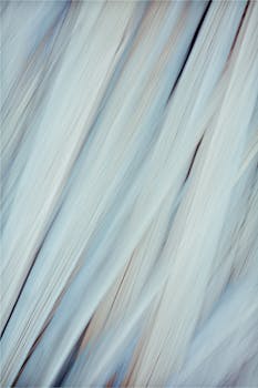 A soft and elegant abstract fabric texture with delicate white and blue hues, creating a serene and dreamy atmosphere.