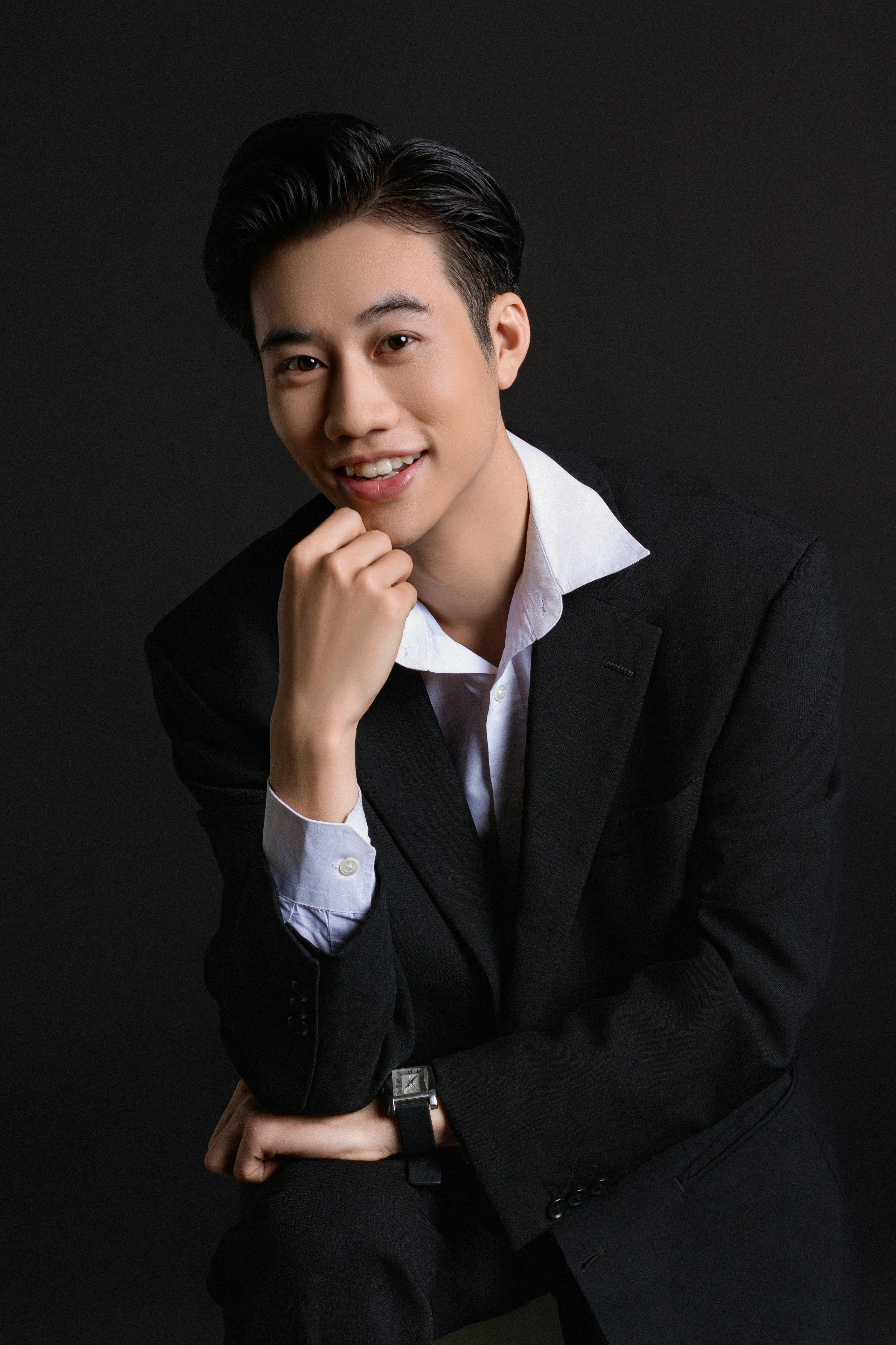 Smiling Southeast Asian business executive in professional black suit