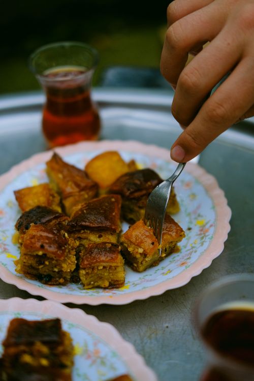Free A close-up of baklava being eaten with Turkish tea in Trabzon. Perfect for food photography enthusiasts. Stock Photo