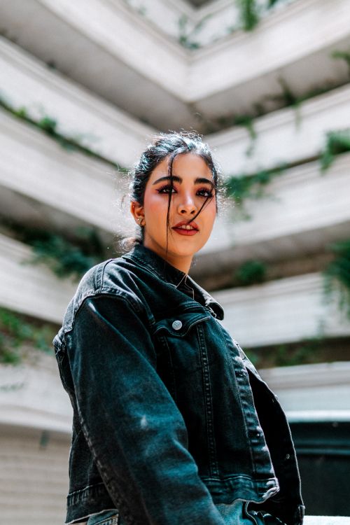 Free Young woman in a denim jacket posing in an urban setting, showcasing modern fashion. Stock Photo