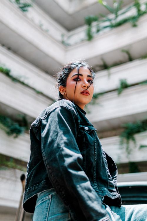 Free Stylish portrait of a woman in an urban setting wearing a denim jacket. Stock Photo