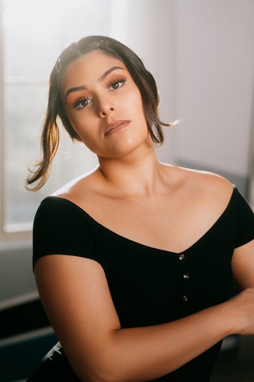 A woman in a black top posing for a portrait