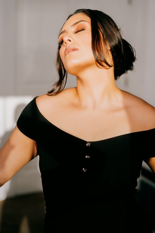 Free A woman in a black dress is looking at the camera Stock Photo