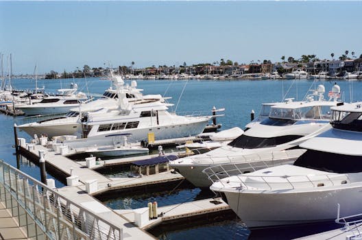 A picturesque view of luxury yachts docked in a vibrant marina under a clear blue sky.