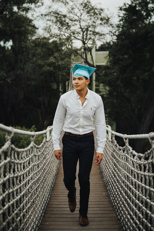 Free A man in a blue hat walking across a bridge Stock Photo