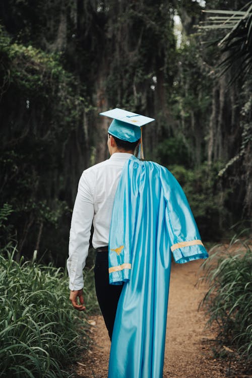 Free Back View of Man in Academic Hat Walking with Gown in Forest Stock Photo