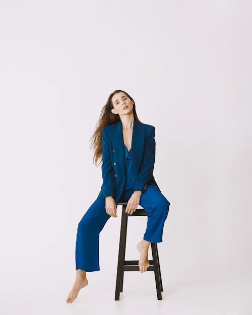 Free A woman in a blue suit sitting on a stool Stock Photo