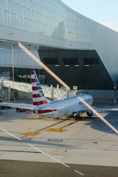 American Airlines plane parked at airport terminal gate, preparing for travel.