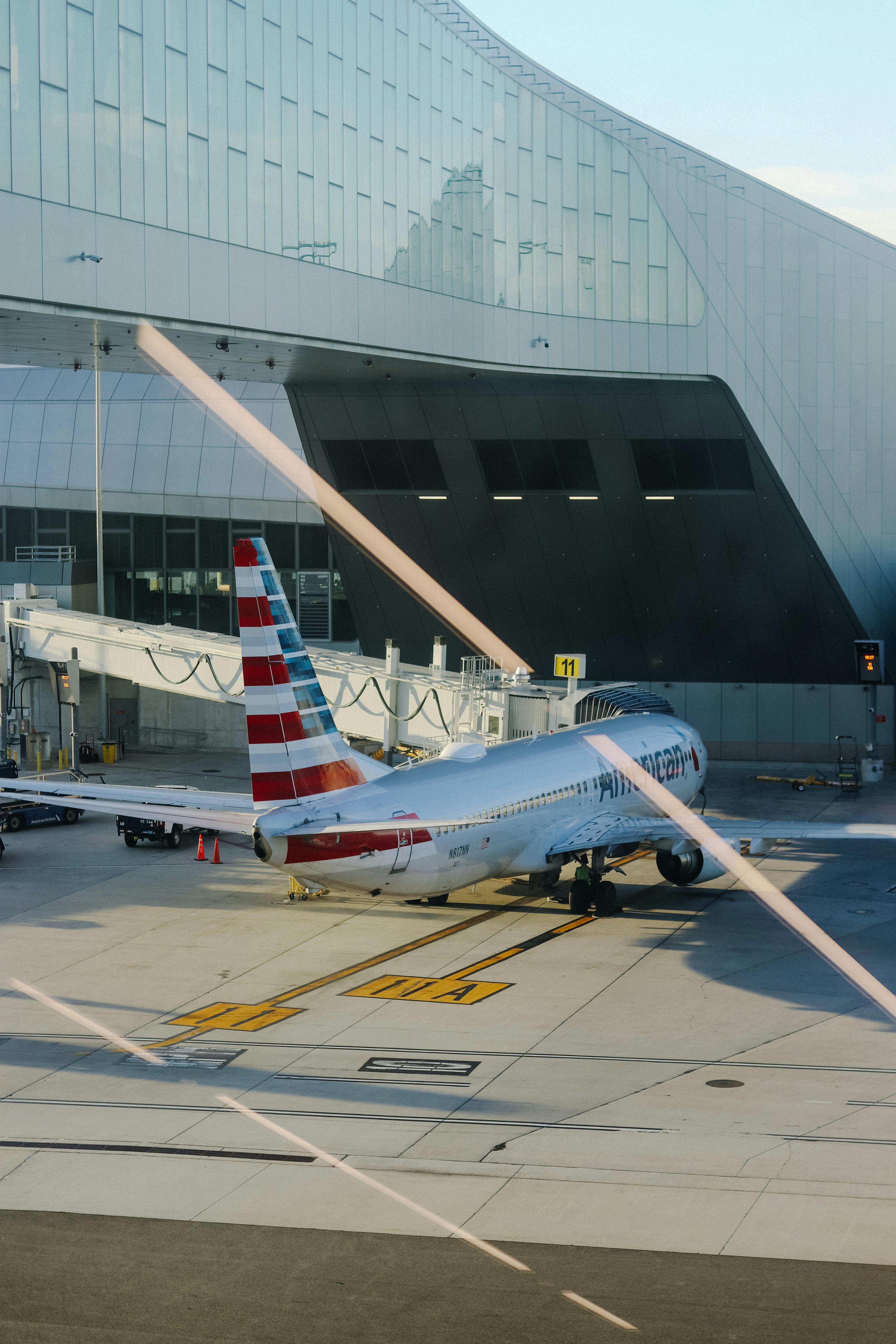 Free American Airlines plane parked at airport terminal gate, preparing for travel. Stock Photo