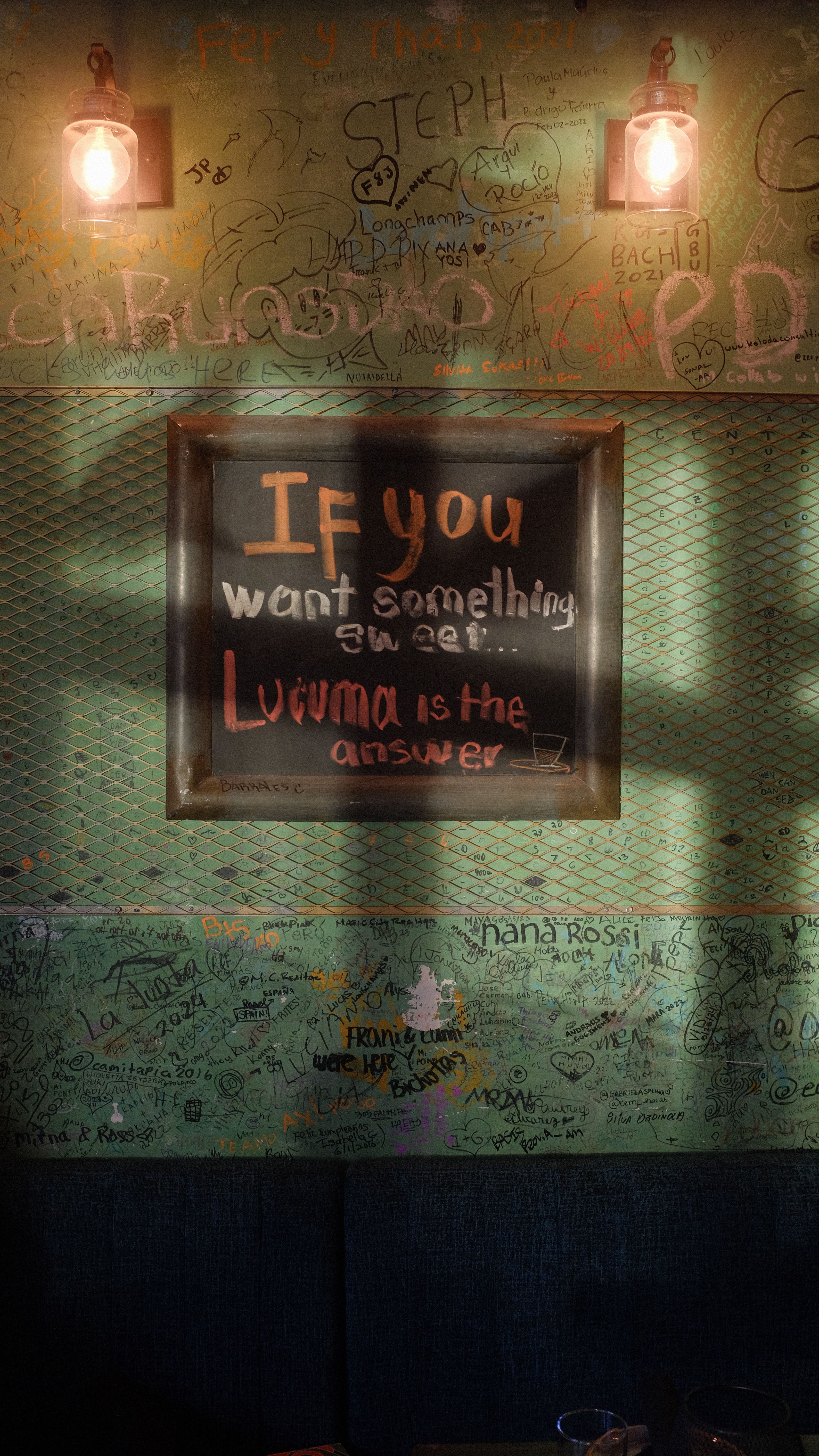 Light Bulbs Glowing over a Framed Message on a Wall Covered in Various ...