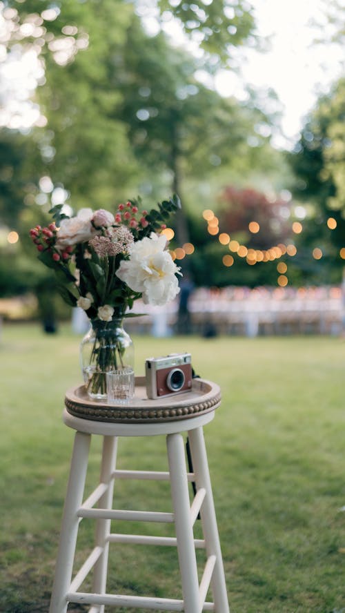 Free A small stool with flowers and a vase on it Stock Photo