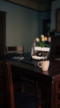 A cozy home workspace with a laptop and mug on a wooden table, creating a warm atmosphere.