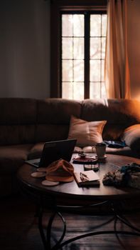 A warm, inviting living room featuring a round table, laptop, and decor items.