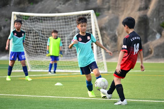 Boys playing soccer during a team training session outdoors on a sunny day.