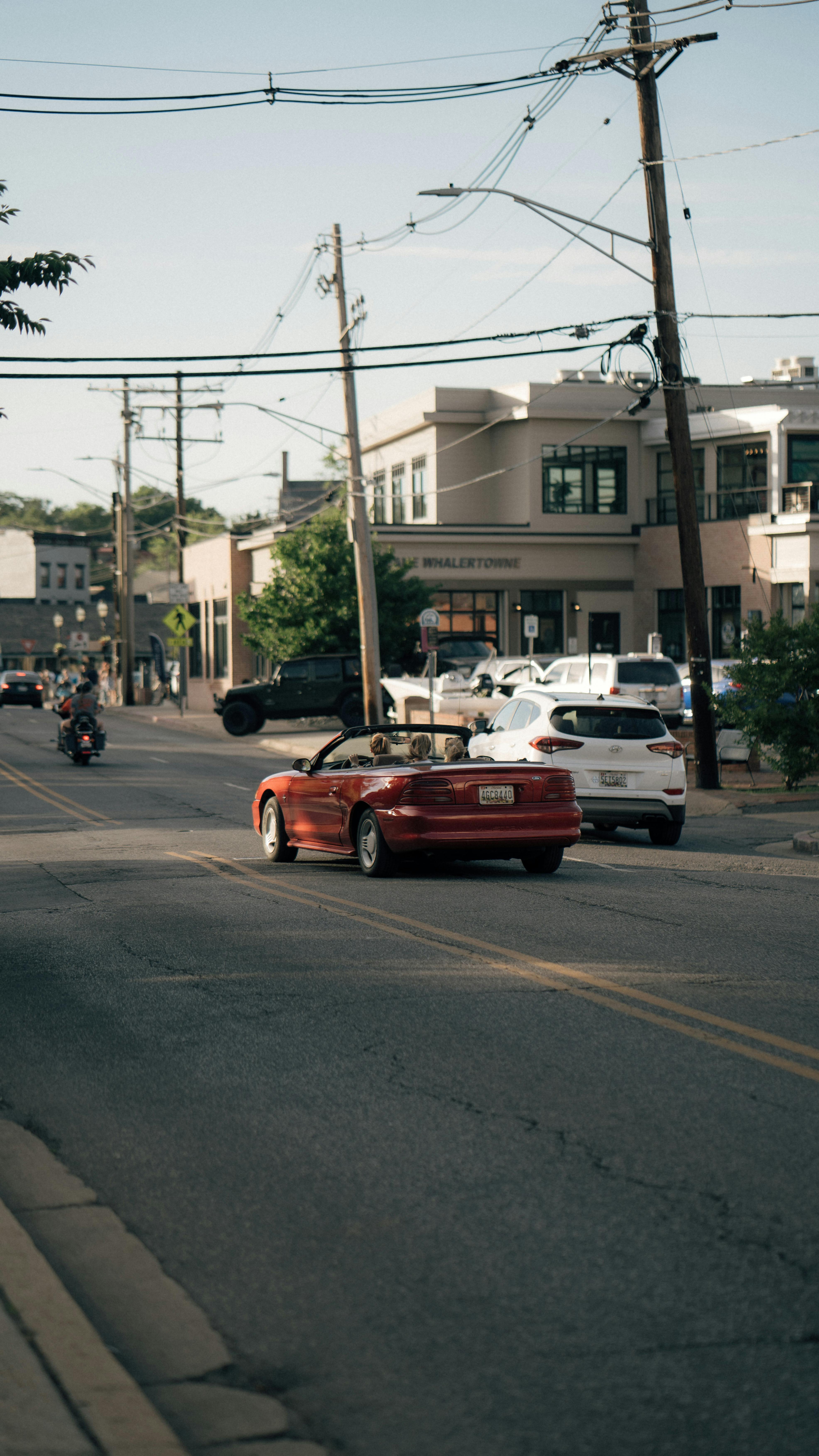 Urban street in Annapolis with cars, power lines, and buildings on a sunny day.