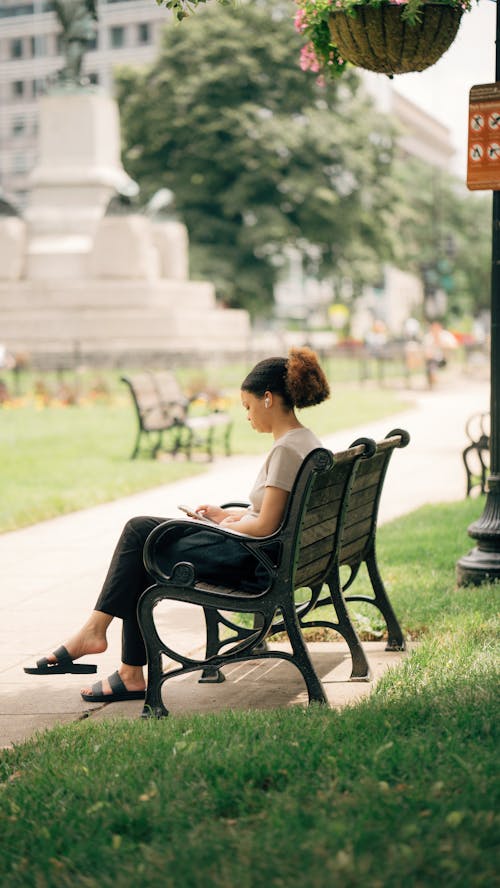 A woman sitting on a bench in a park