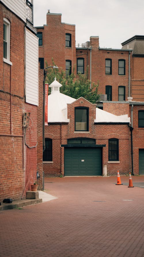 A brick walkway with a red brick building