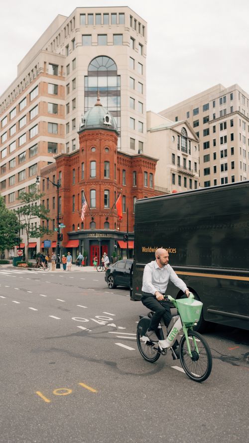 Free Cyclist navigating city streets with iconic architecture in Washington, DC. Stock Photo