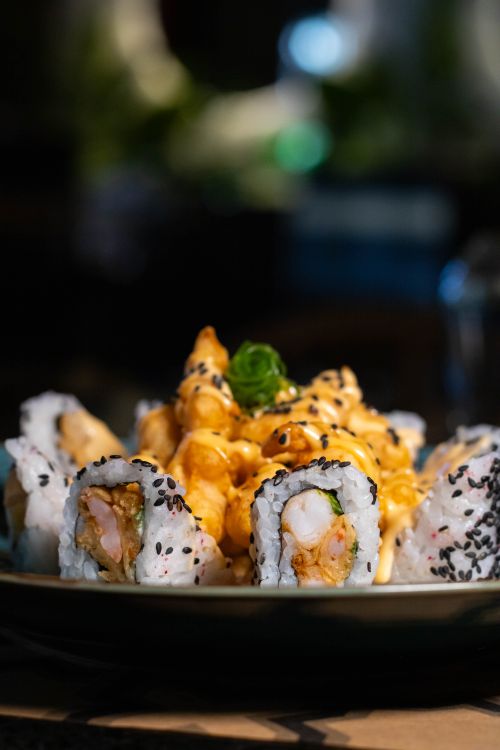 Free Delicious gourmet sushi rolls with seafood, elegantly plated and garnished, perfect for culinary enthusiasts. Stock Photo