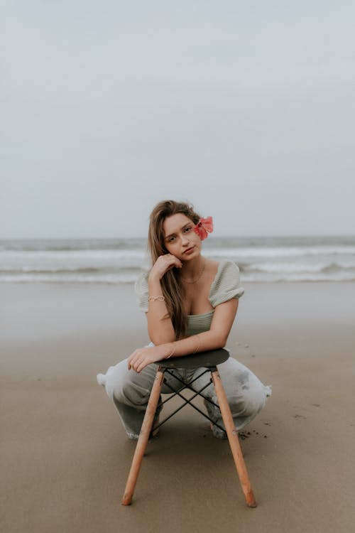 A woman sitting on a chair on the beach