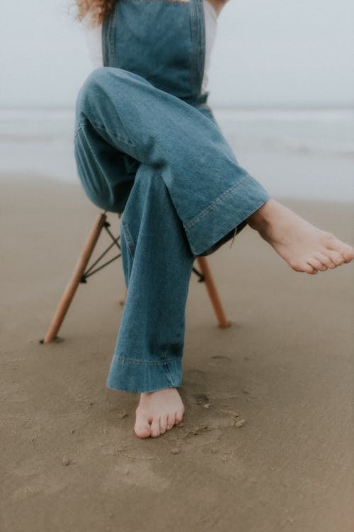 Free A woman sitting on a beach chair with her feet up Stock Photo