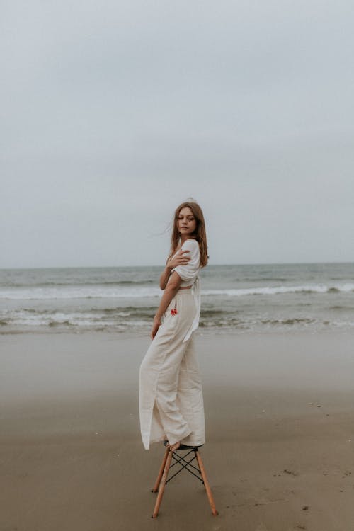 A woman standing on a stool on the beach