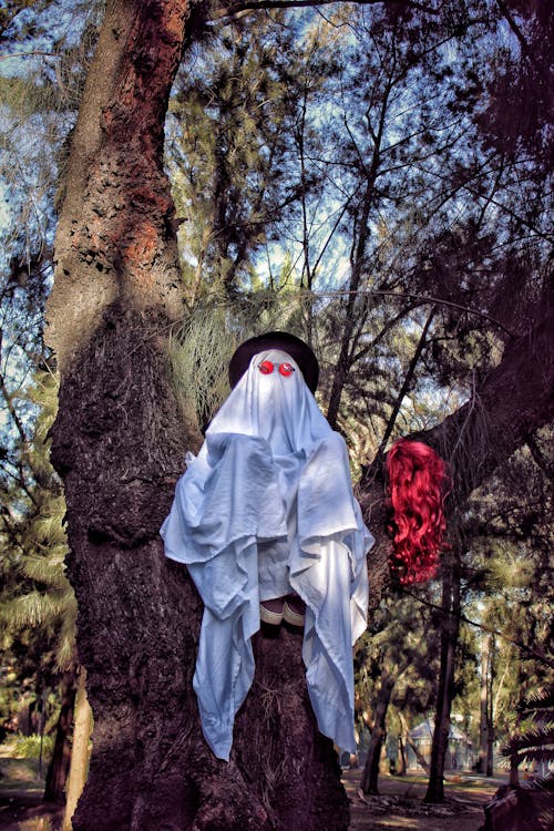 A ghost is sitting on a tree in the woods