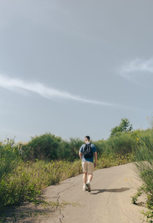 Free A man with a backpack hikes on a rural path surrounded by greenery in Tirana County, Albania. Stock Photo