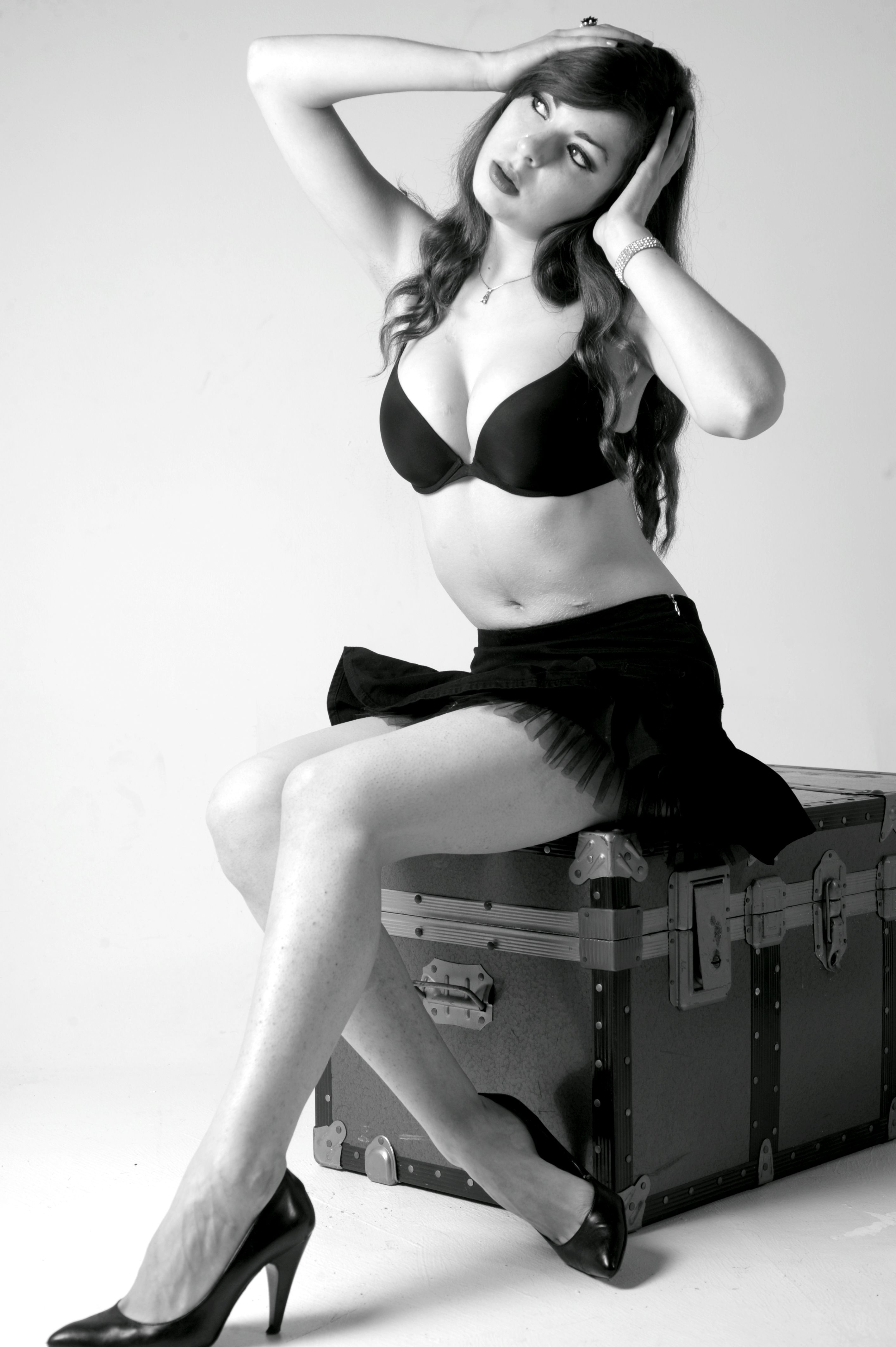 Studio portrait of a woman posing in black lingerie and heels, exuding elegance and style.