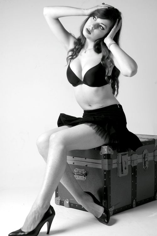 Free Studio portrait of a woman posing in black lingerie and heels, exuding elegance and style. Stock Photo