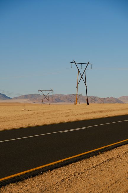 Desert highway with utility poles under a clear sky, perfect for travel and adventure themes.