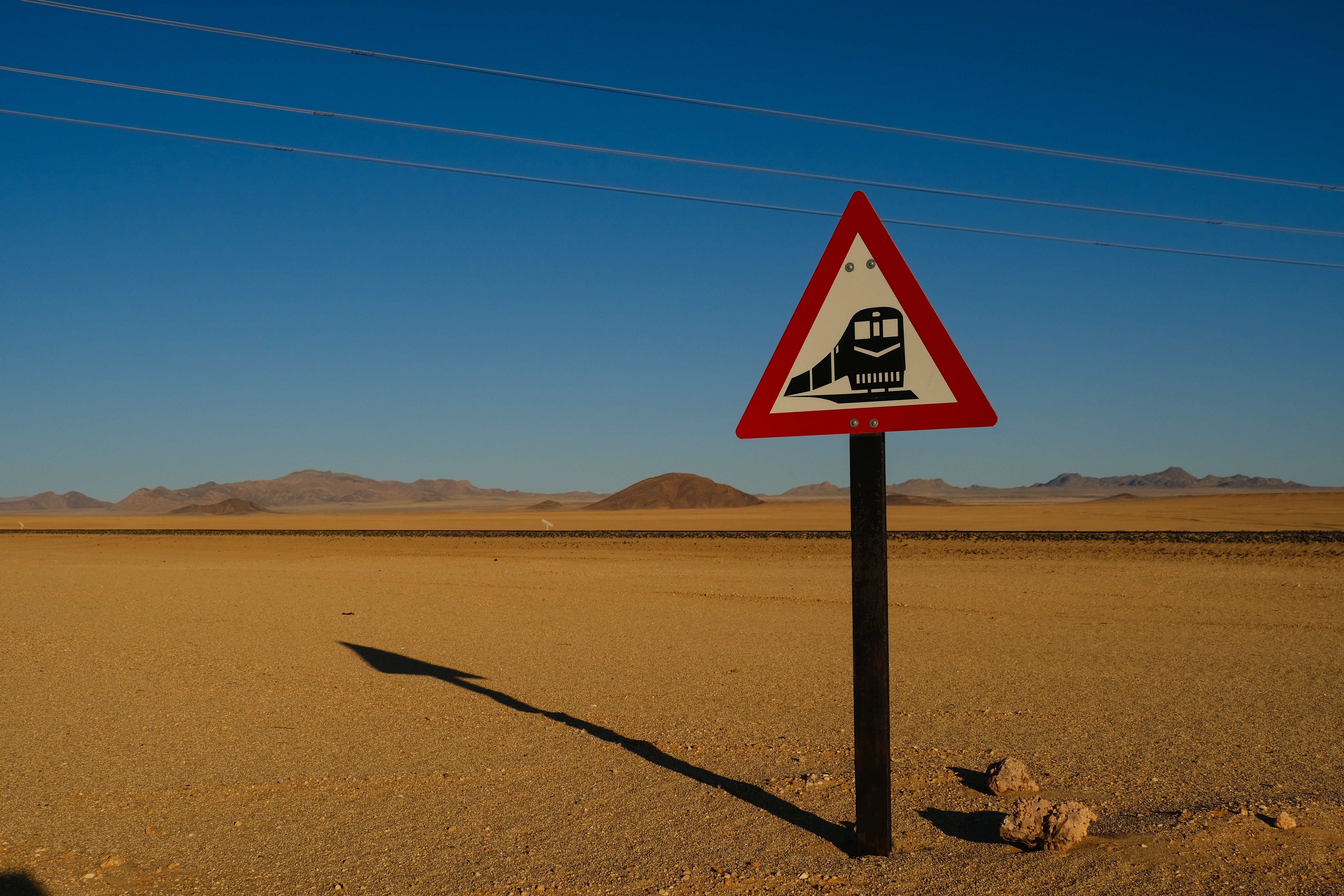 A sign warning of a train in the desert · Free Stock Photo
