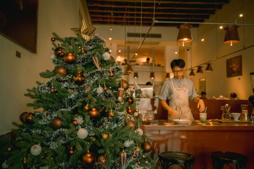 Free Christmas tree decoration in a Ho Chi Minh City café, capturing festive vibes indoors. Stock Photo