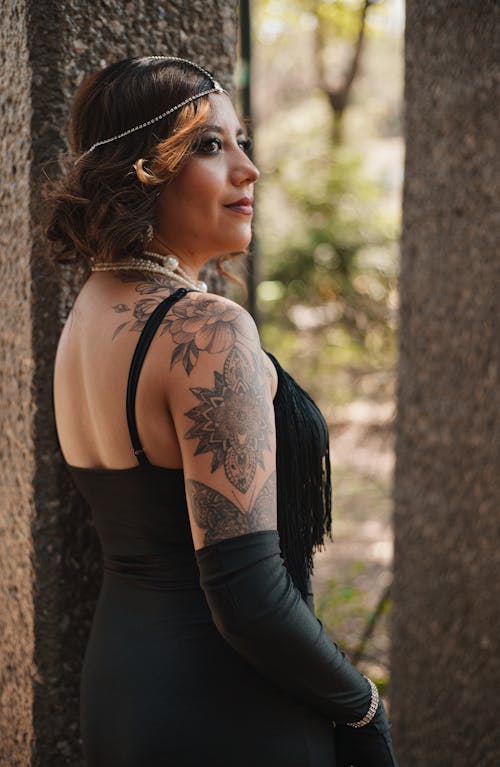 A woman with tattoos and a black dress