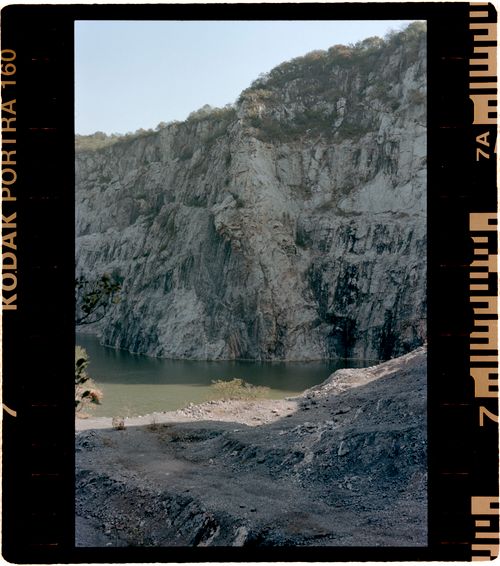 Free Serene view of a rocky cliff beside calm waters, captured with a vintage film look. Stock Photo