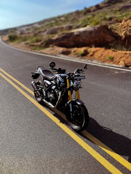Black motorcycle parked on a scenic road in Bengaluru, India, under clear skies.