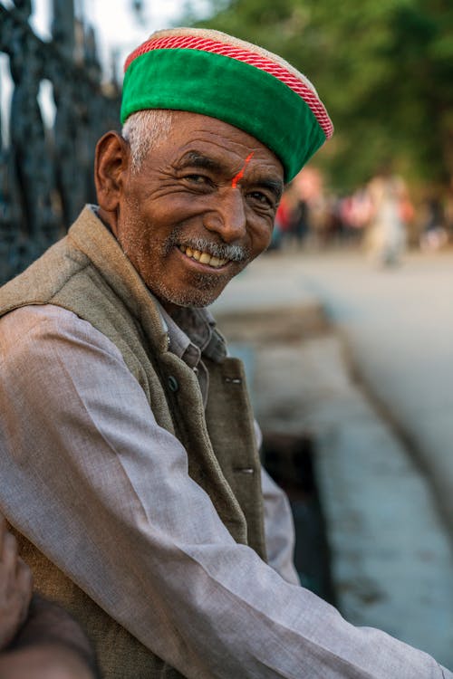 Free Portrait photo of a cheerful elderly man sitting down Stock Photo