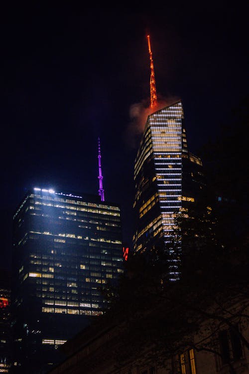 The new york city skyline is lit up with red and purple lights