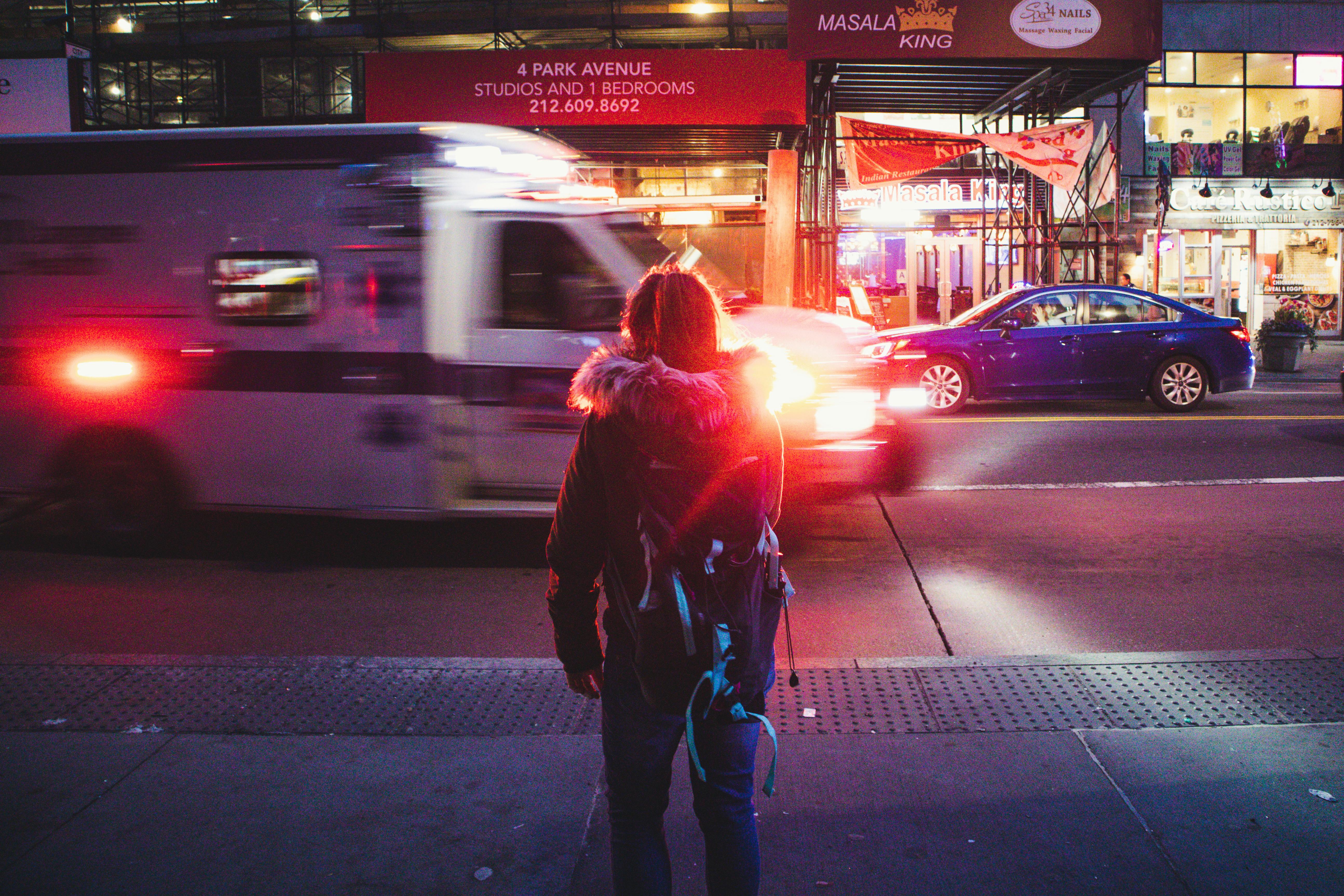 back view of woman standing on sidewalk