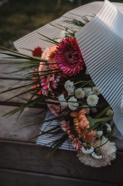 Stunning bouquet of flowers wrapped in paper displayed on a rustic wooden bench, perfect for decor inspiration