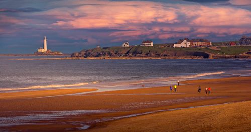 Free Picturesque beach with St Mary's Lighthouse during sunset at Whitley Bay, England. Stock Photo