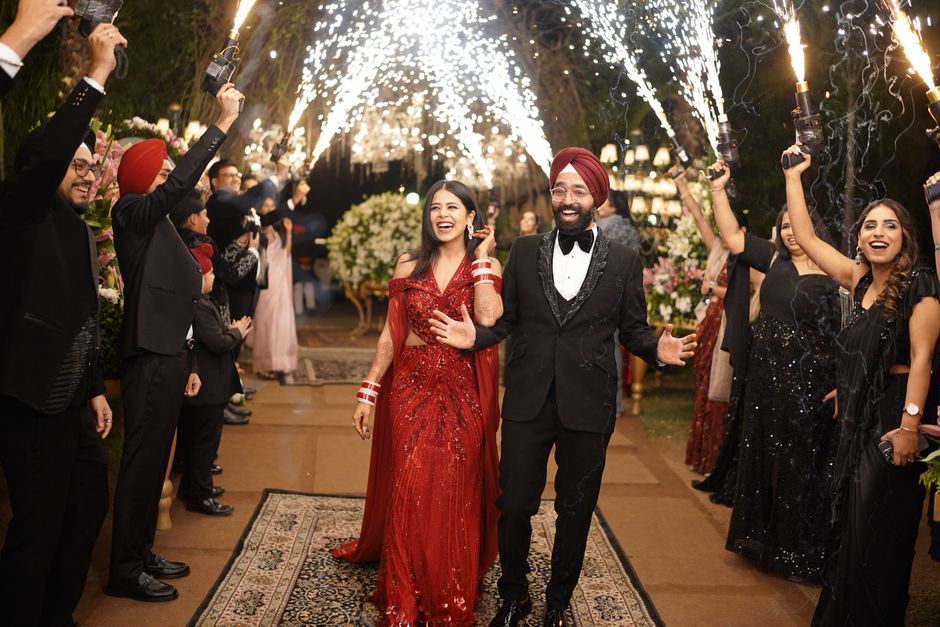Joyful Indian wedding with bride and groom amid sparklers, vibrant traditional attire, and happy guests in Chandigarh.