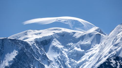 Free Dramatic image of a snowcapped mountain peak against a clear blue sky, perfect for travel and nature themes. Stock Photo