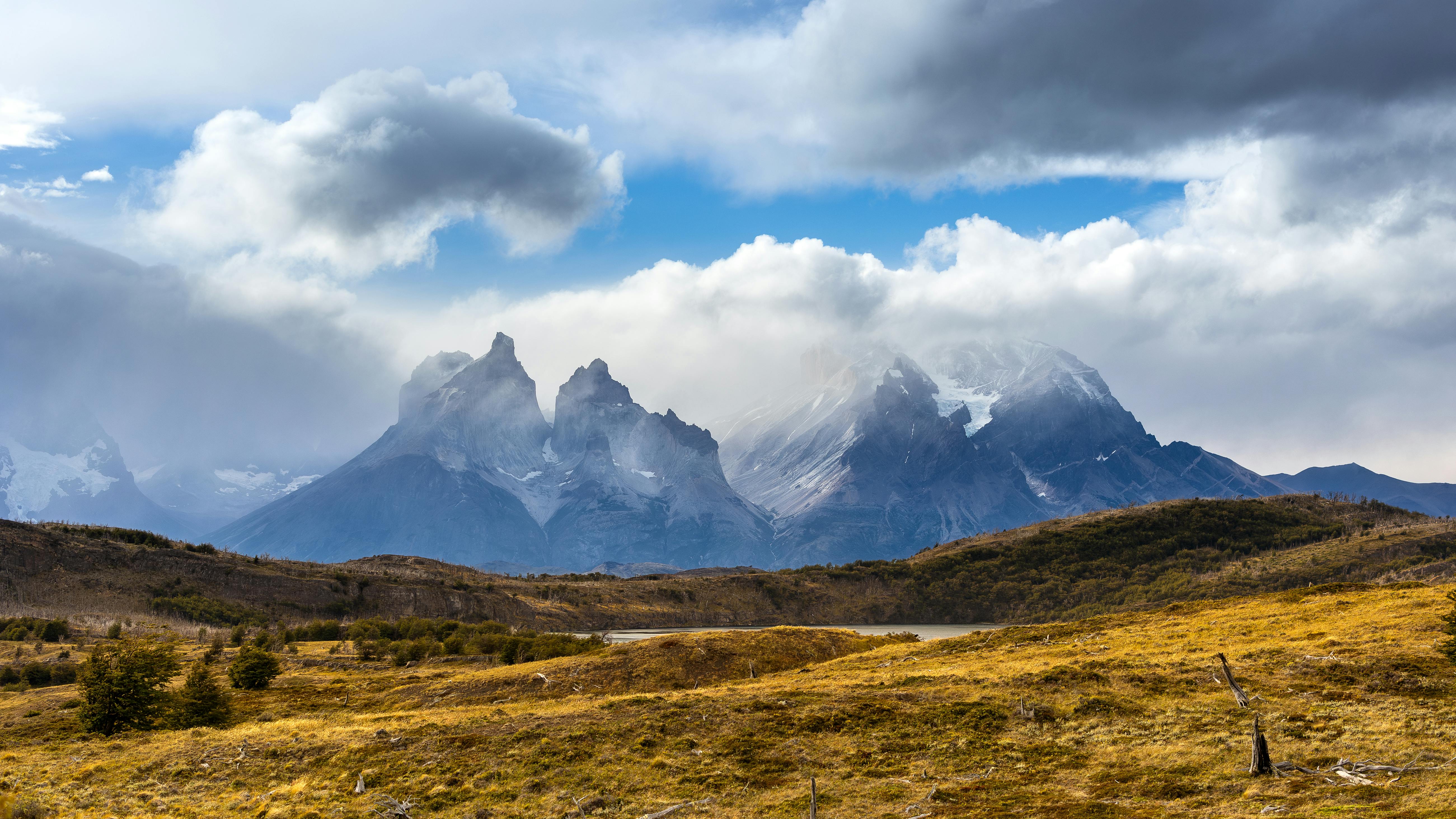 A scenic view of rugged mountains under a dramatic cloudy sky, showcasing natural beauty.