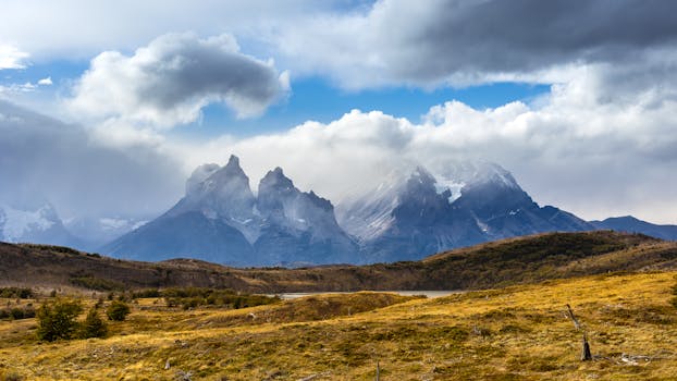 A scenic view of rugged mountains under a dramatic cloudy sky, showcasing natural beauty.