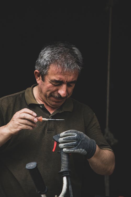 Free A man is cutting a piece of metal with a pair of scissors Stock Photo