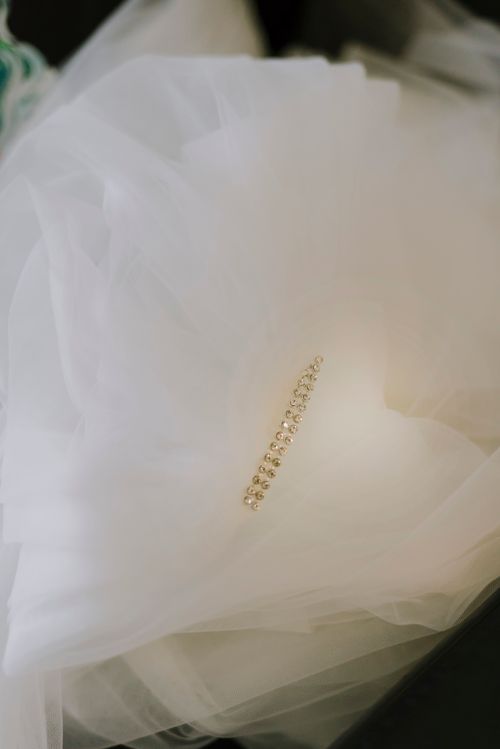 Free A beautiful golden hairpin with diamonds elegantly rests on soft white fabric. Stock Photo