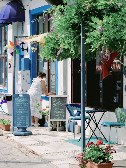 Free View of a vibrant café exterior with colorful decor and plants, capturing a sunny day ambiance. Stock Photo